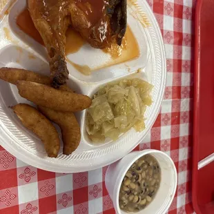 Bbq chicken plate with sides of cabbage and black eyed peas