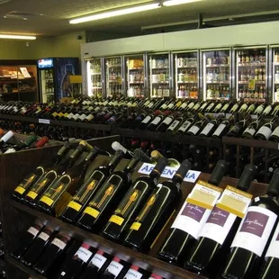 three rows, stacked of wine bottles separated by regions