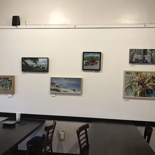 a dining room with paintings on the wall