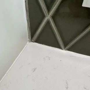 More grout coming out from the quartz and where the tile meet from improper installation.