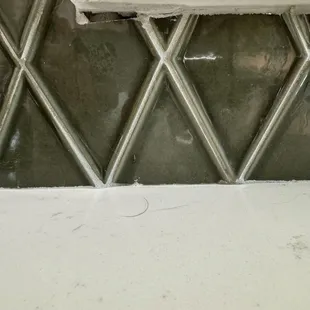 Uneven cut tile and not filled in with grout.