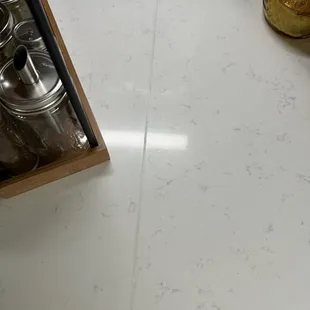 Hole and black and white seal in quartz counter top. Left glue all over countertop.