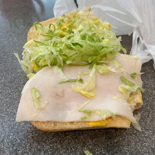 a sandwich with lettuce and cheese