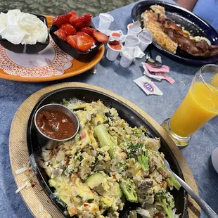 a plate of food and a glass of orange juice