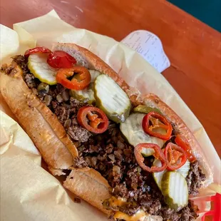 Cheese steak sandwich with pickles and jalapenos