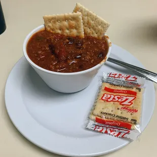 a bowl of chili and crackers