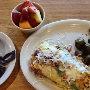 My omelette. Added hollandaise.  Side of sweet and spicy bacon sides of fruit and Brussel Sprouts and Coffee.