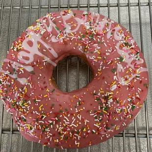 a pink frosted donut with sprinkles