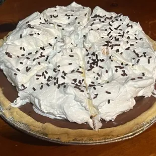 a chocolate pie with whipped cream and chocolate sprinkles