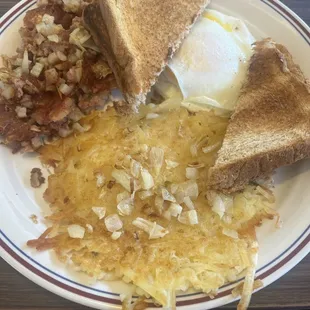 Eggs over medium. Cornbeef hash. Hash Browns. Wheat toast.
