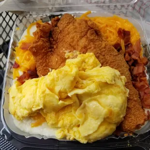Catfish and grits bowl with eggs scrambled, cheddar cheese, bacon crumbles and side of cornbread and apple sauce.