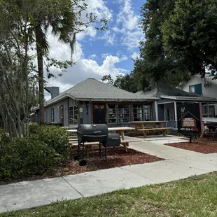 Front entrance of restaurant showing outside tables and sidewalk. Street parking available.
