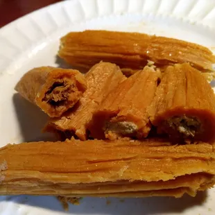 a close up of a piece of tamales on a paper plate