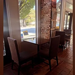 a table and chairs facing a window