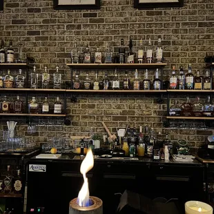 a brick wall with shelves filled with liquor bottles