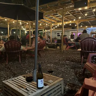 people sitting at tables under an umbrella