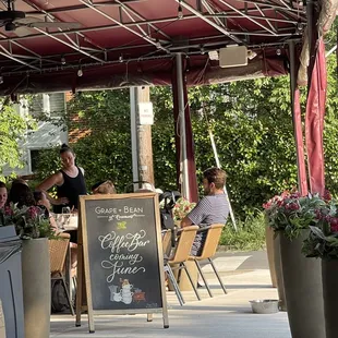 people sitting at tables under a canopy