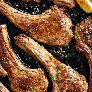 lamb chops in a pan with lemon wedges