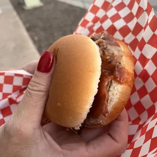 a person holding a hamburger in their hand