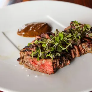 a piece of steak on a white plate