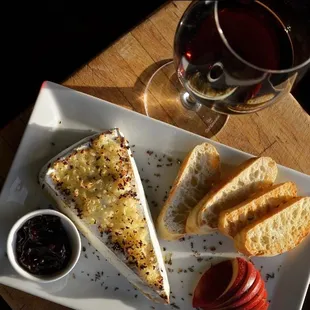 Warm Bree with toasted garlic, farmers market jam, fresh apple slices, and toasted baguette slices.