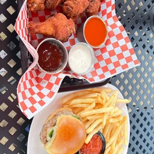 a basket of chicken wings and a plate of french fries