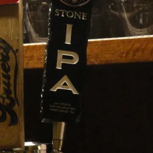 a beer tap with beer glasses in the background