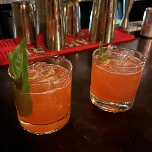 two glasses of orange juice with a garnish