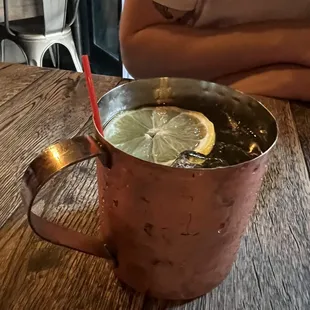 a person sitting at a table with a cup of lemonade