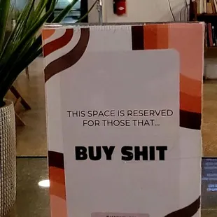 This sign is funny...but I get it! If you wanna sit on the couch u gotta Buy Shit! Makes sense.