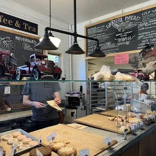 a man standing in front of a bakery counter