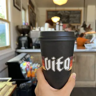 a hand holding a coffee cup