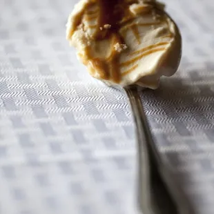 a spoon with ice cream and caramel