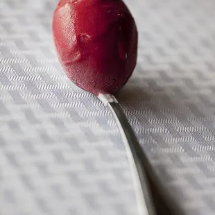 a spoon with a red gelato on it