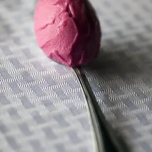 a spoon with a pink gelato on it