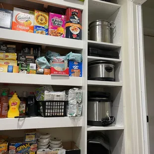 Appliance garage inside an insulated pantry built in a garage. Canned goods and large bags stored on reinforced shelves.