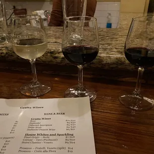 three glasses of wine on a bar
