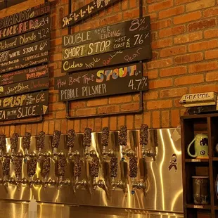 a brick wall with a variety of beer taps