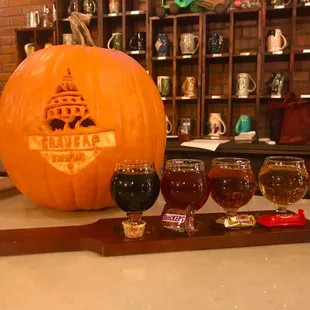 a pumpkin carved into a beer glass