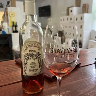 a bottle of pink wine and a wine glass