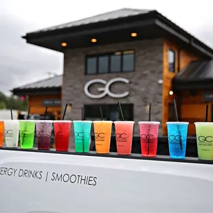 a variety of smoothies lined up on the back of a truck