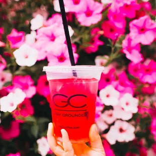 a hand holding a cup with a straw