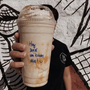 a person holding a cup of iced coffee