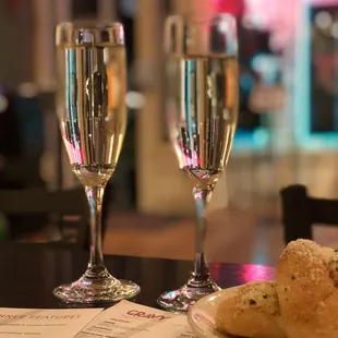 two glasses of champagne and a plate of bread