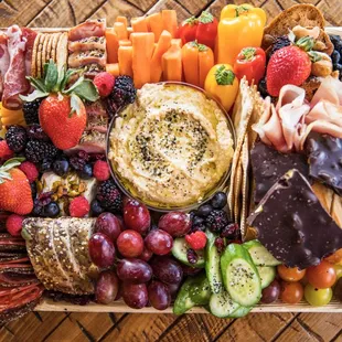 a platter of cheese, fruit, and crackers