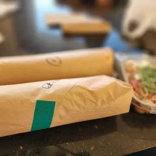 two wrapped sandwiches on a table