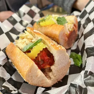 two hot dogs on a checkered paper plate