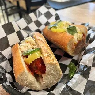 two hot dogs on a checkered paper wrapper