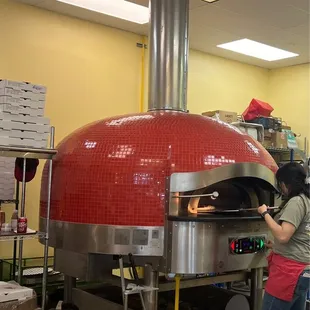 a woman working in a pizza oven