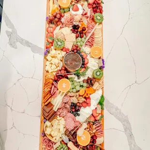 a platter of meat, cheese, and fruit